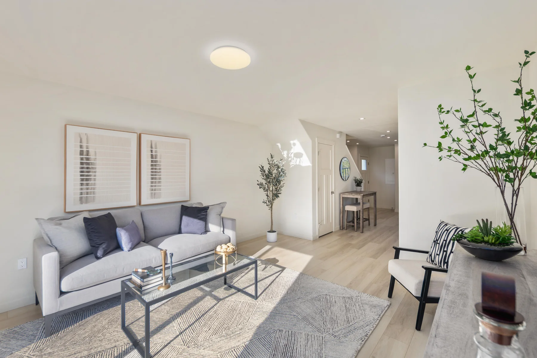 Furnished living room with sofa, coffee table, and light wood flooring